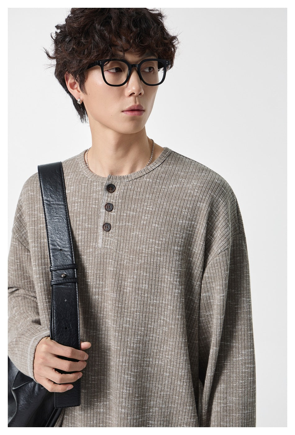 Close view of a model wearing a taupe-gray ribbed Henley with a three-button placket.