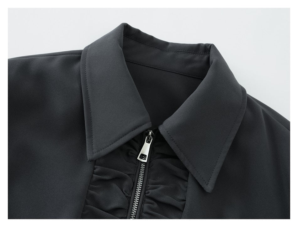Close-up of the jacket's pointed collar, silver zipper, and gathered front trim.