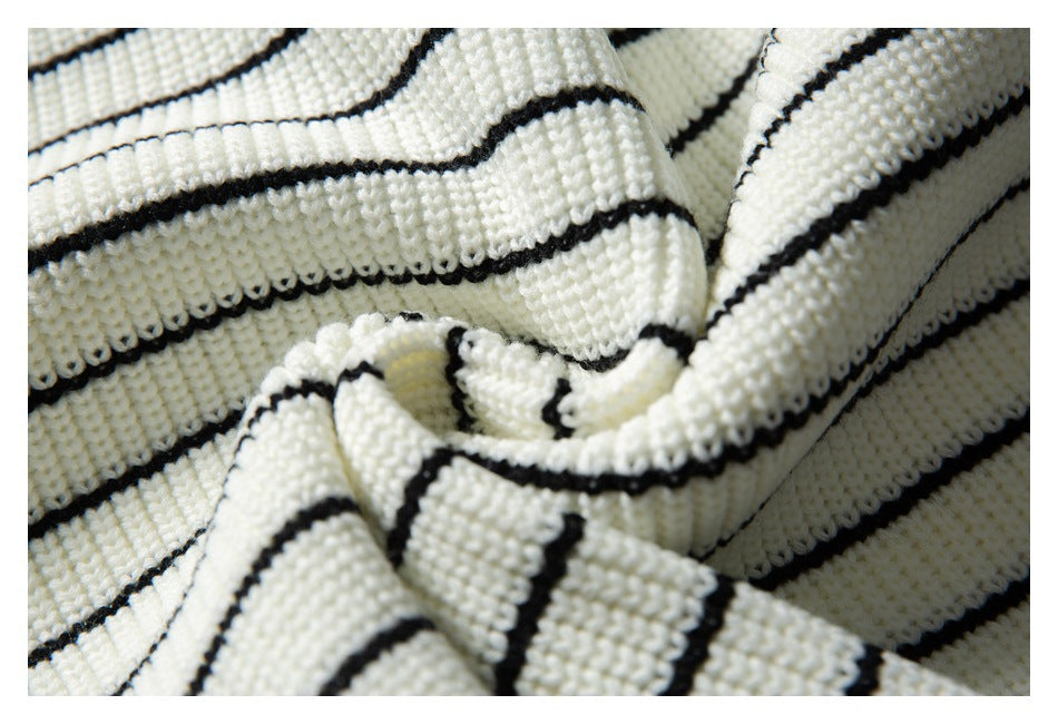 Close-up of ivory knit fabric with narrow black stripes gathered into soft folds.