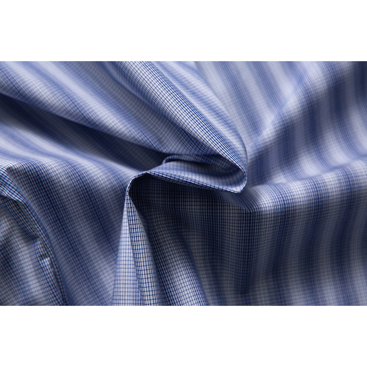 Macro view of blue-and-white checked shirt fabric gathered into soft folds.