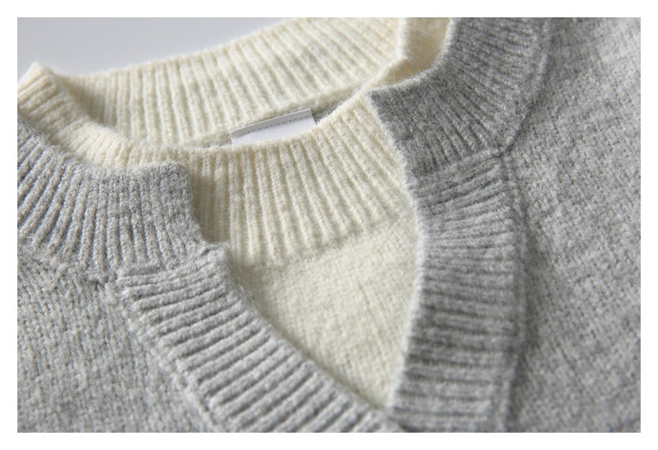 Close-up of the gray V-neckline layered over a cream ribbed collar and inner panel.