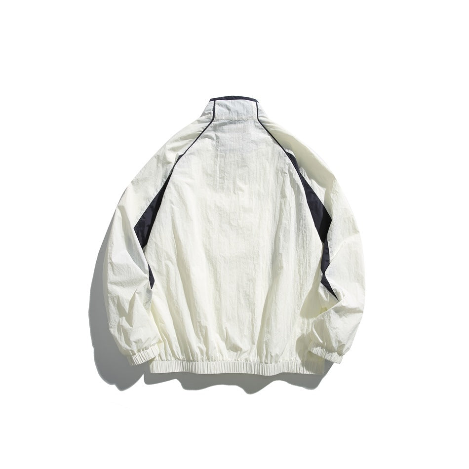Back view of a white jacket with dark contrasting panels, a high collar, elastic cuffs, and an elastic hem.