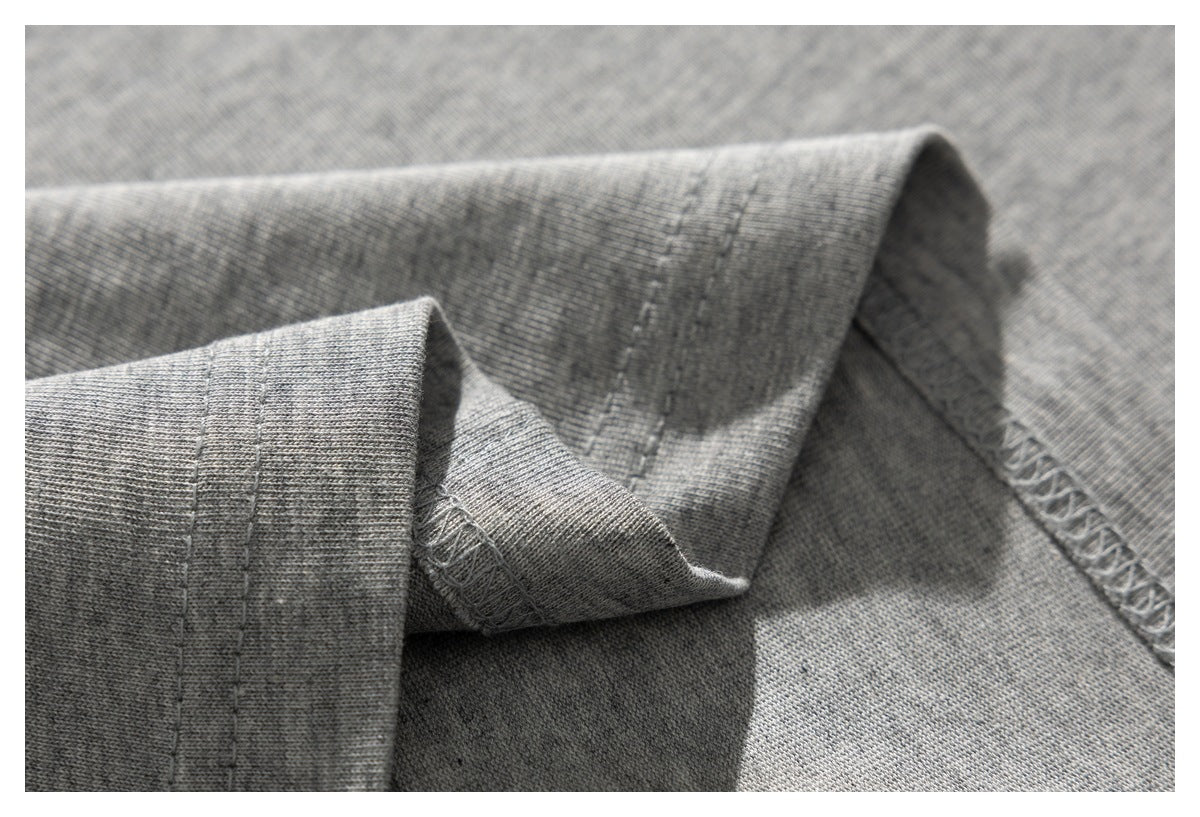 Close-up of a gray knit garment's folded cuff and overlocked seam.