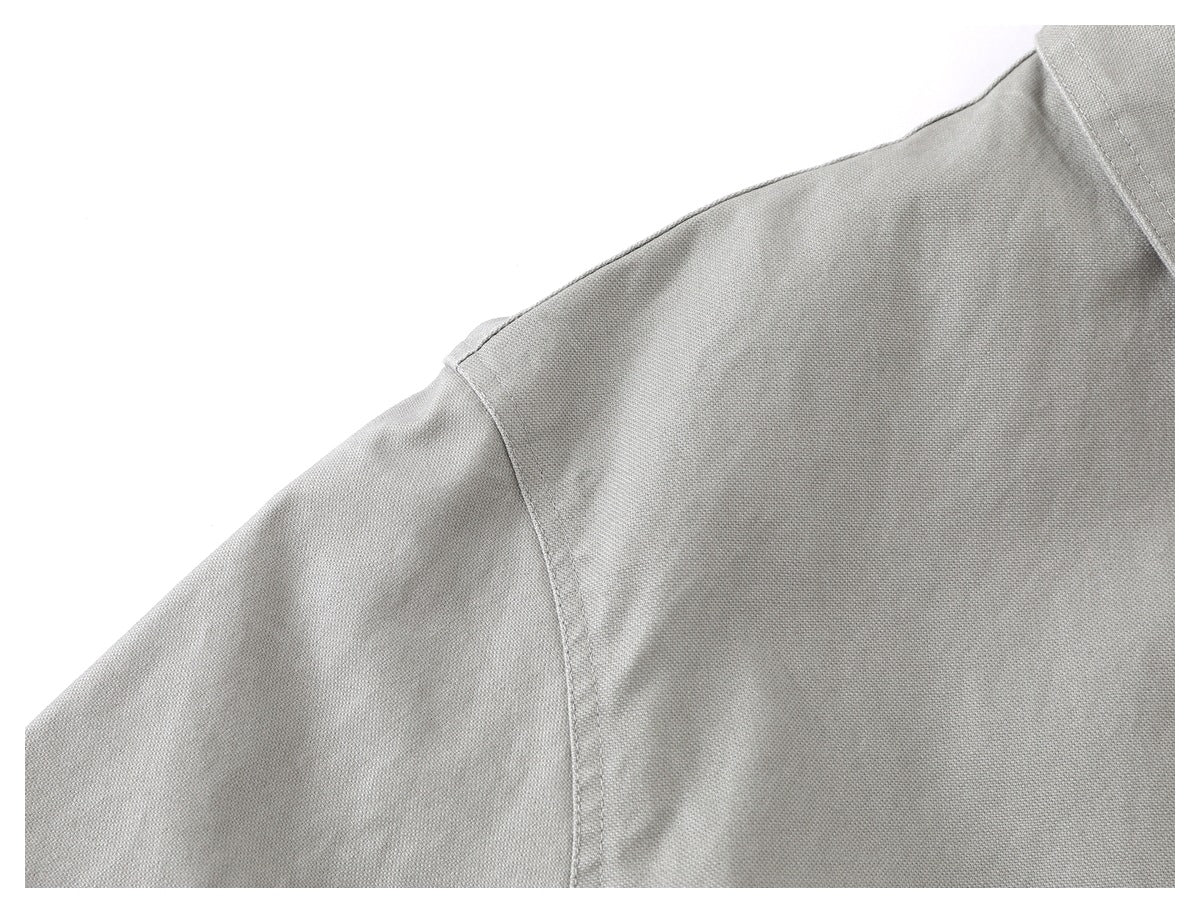 Close-up of the light gray jacket's shoulder seam, sleeve, and collar edge.