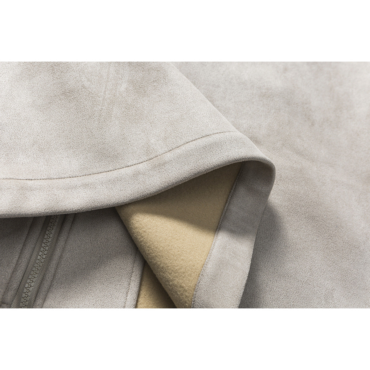 Close-up of a taupe jacket sleeve cuff turned back to show the beige lining and stitching.