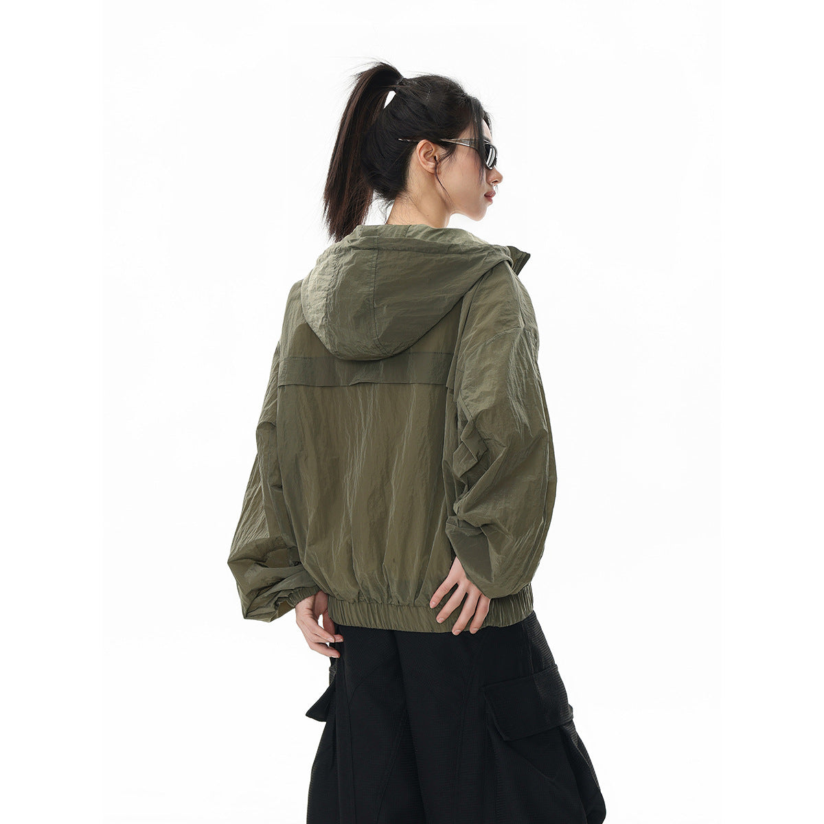 Model wearing an olive hooded jacket, shown from the back with the hood down.