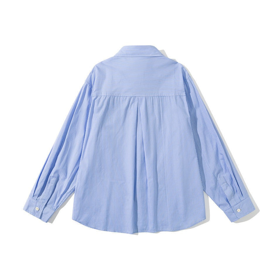 Back view of a light blue, finely striped long-sleeve shirt with a yoke seam, center pleat, and button cuffs.