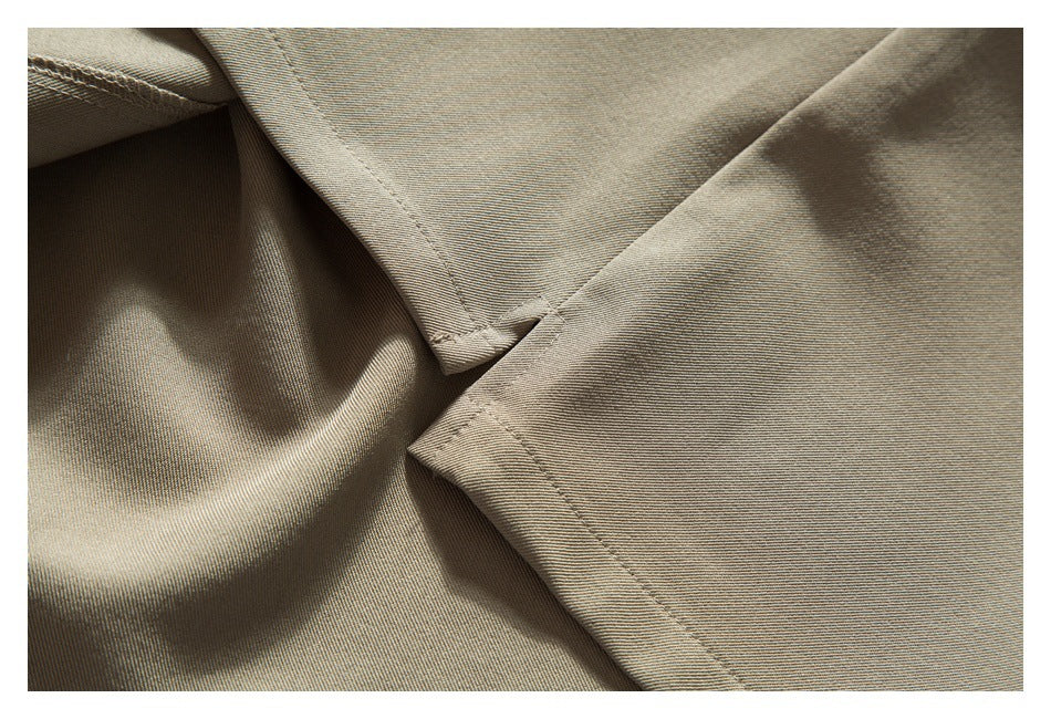 Close-up of intersecting stitched edges on a beige garment, showing the seam construction.