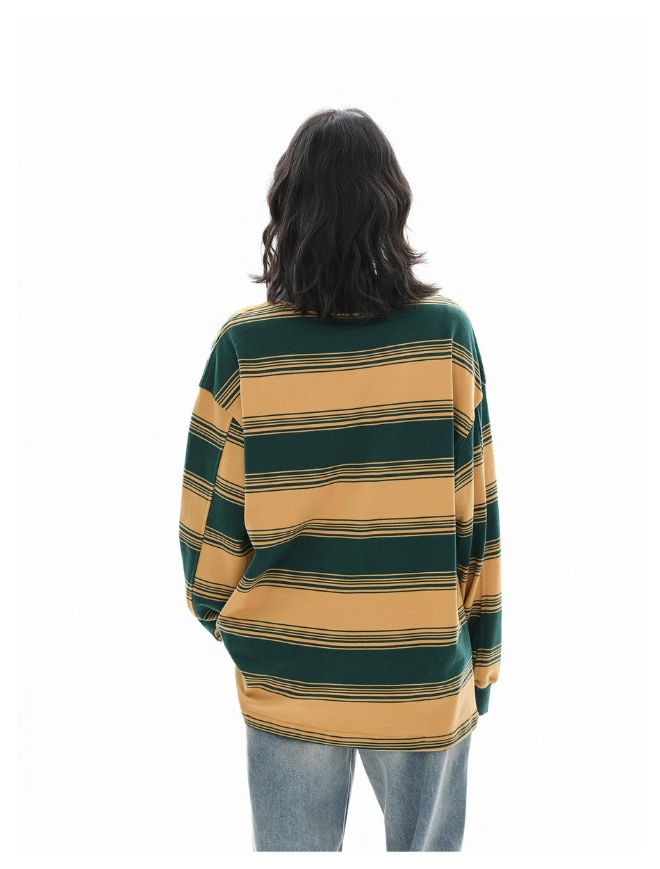 Back view of a model wearing a loose green and mustard horizontally striped long-sleeve shirt.