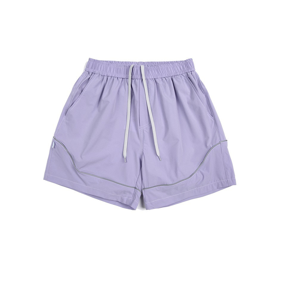 Purple elastic-waist shorts with white drawstring, side pockets and curved gray piping, flat lay front view