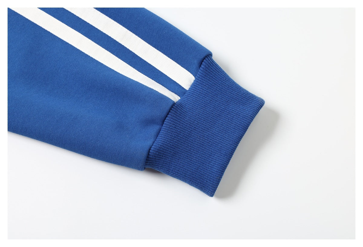 Close-up of a blue sleeve with two white stripes ending above a ribbed blue cuff.