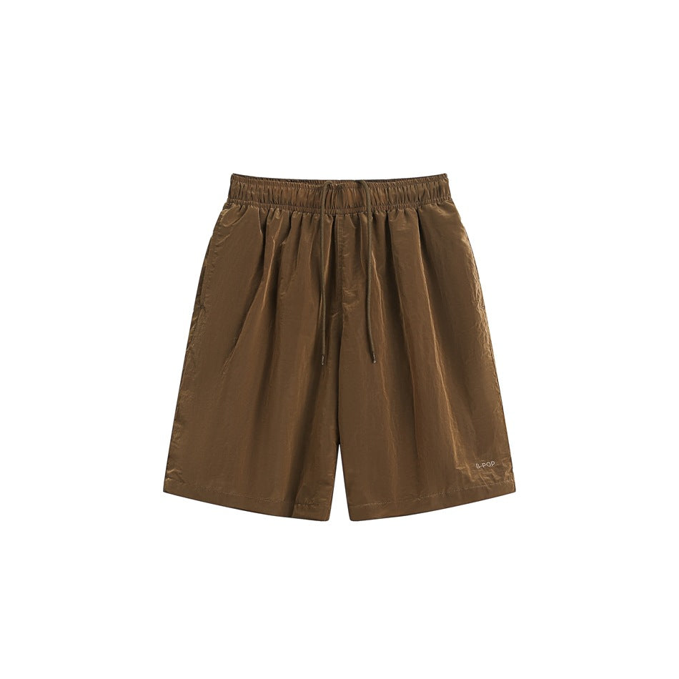 Brown knee-length drawstring shorts with elastic waistband and crinkled finish, flat front view