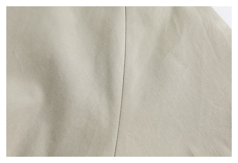 Close-up of pale beige jacket fabric with a vertical seam.