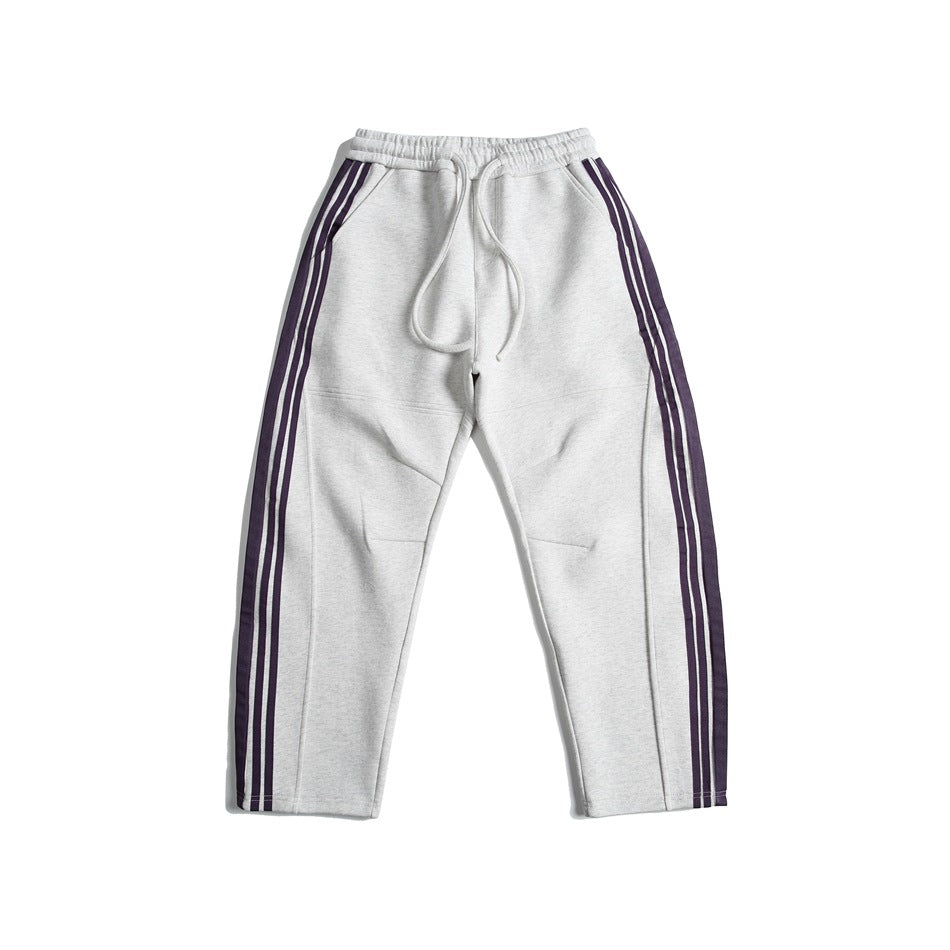 White heather gray sweatpants with purple triple side stripes, drawstring elastic waist, flat lay front view