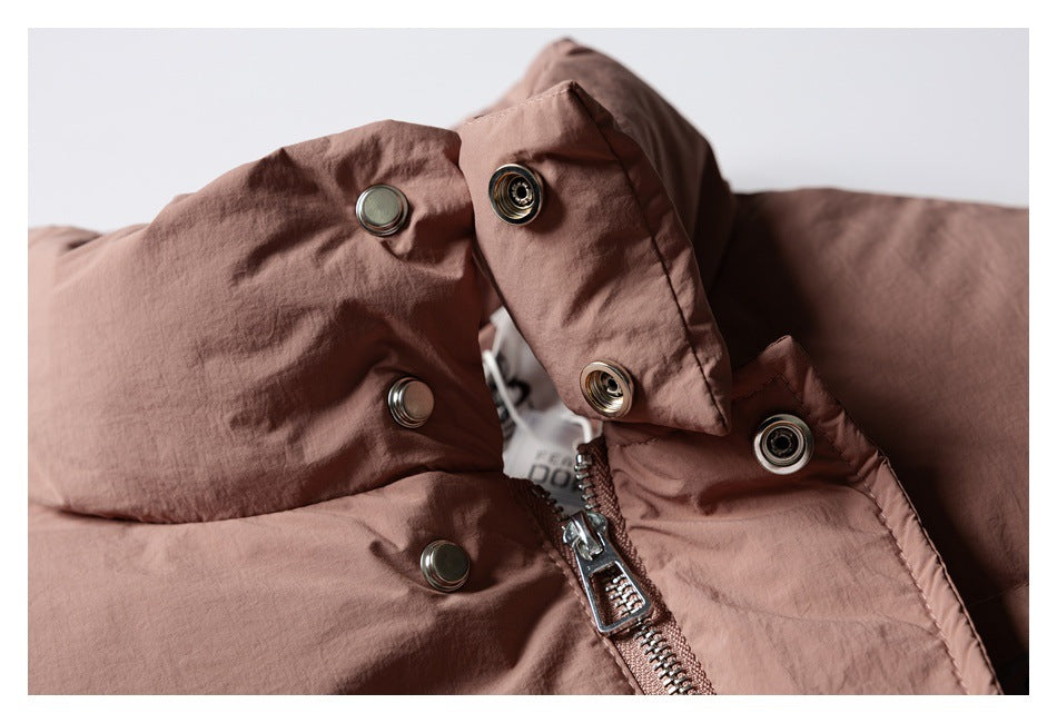 Close-up of the dusty rose jacket's metal zipper and snap-fastened storm flap.