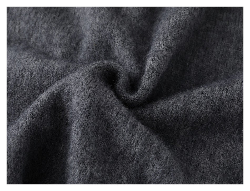 Close-up of charcoal gray knit fabric folded to show its soft-looking surface and drape.