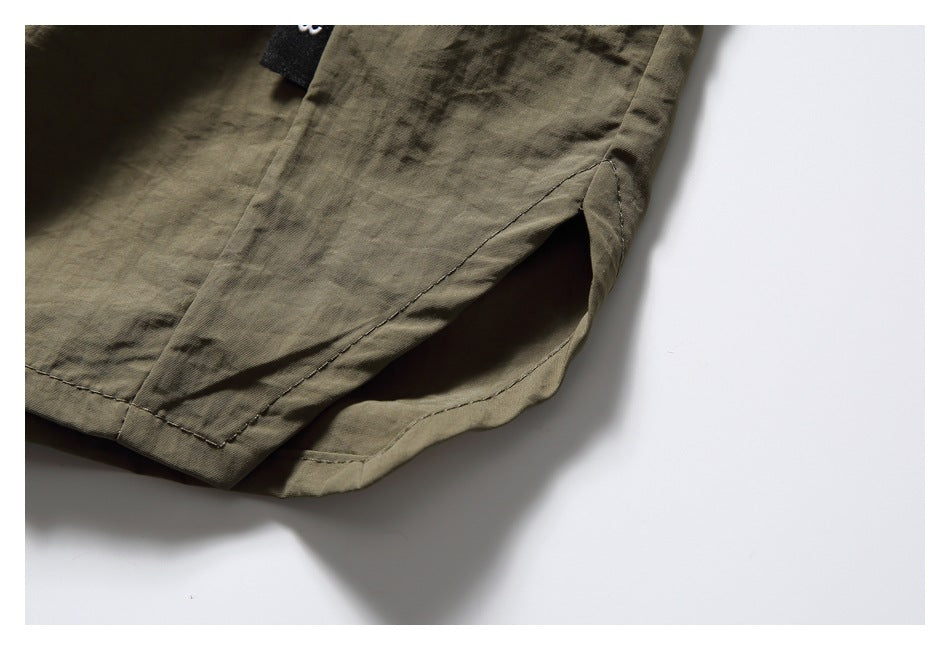 Close-up of an olive-brown shirt hem with a side slit and visible stitching.