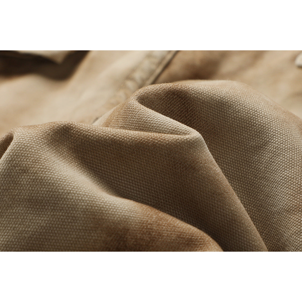 Close-up of the tan-brown shorts fabric, draped to show its textured weave.
