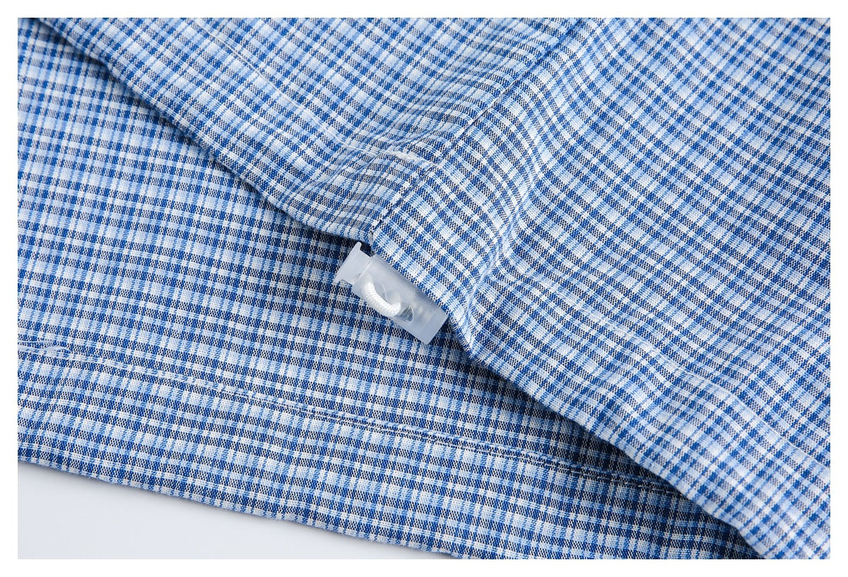 Close-up of blue-and-white checked fabric with a clear plastic tag fastener attached.