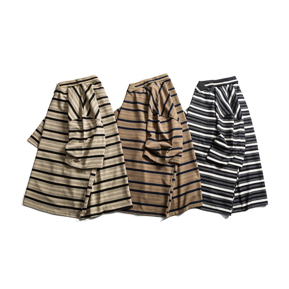 Three short-sleeve striped shirts laid out in beige and black, tan and navy, and black and white colorways.
