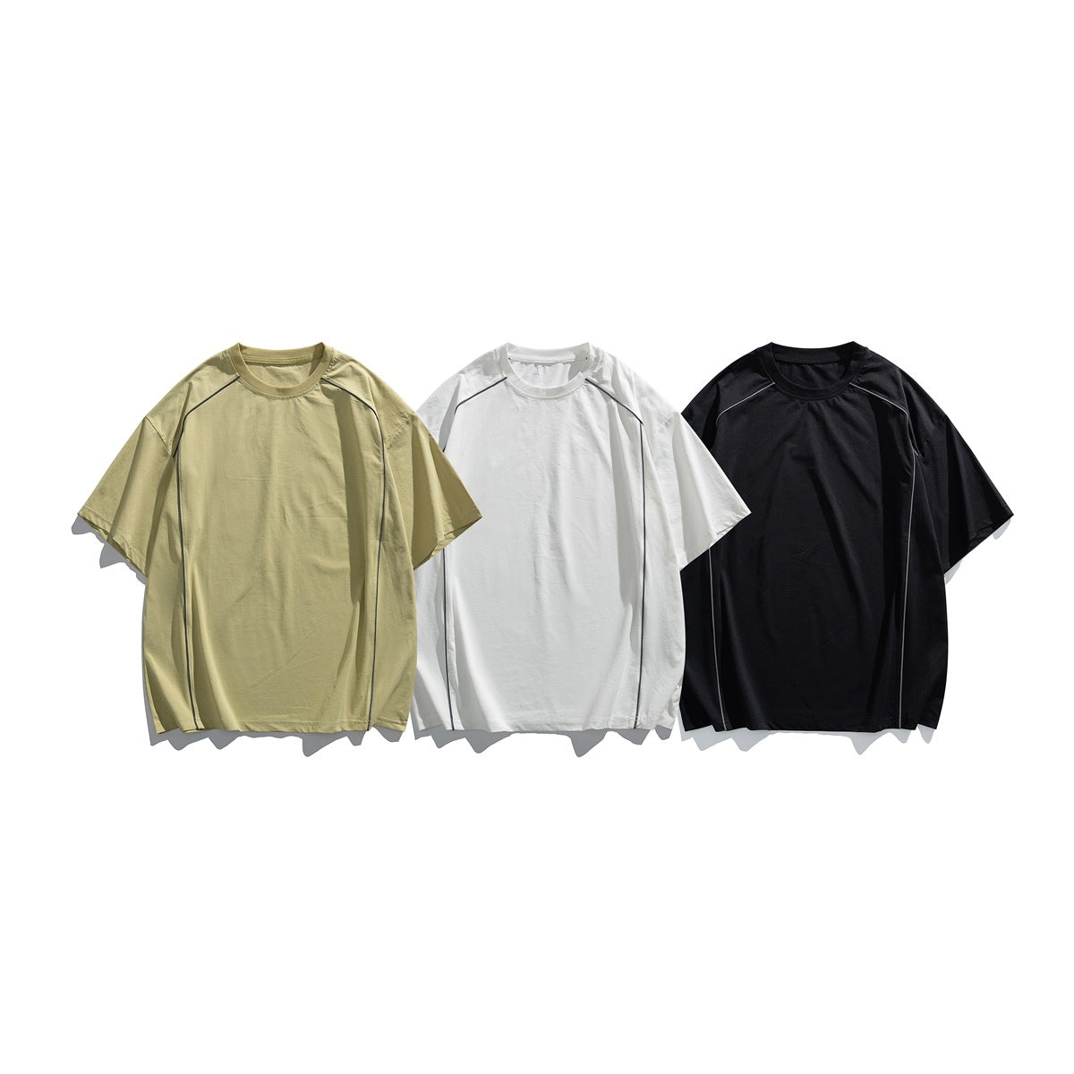 Three short-sleeve raglan T-shirts shown from the front in khaki, white, and black, each with dark piping.