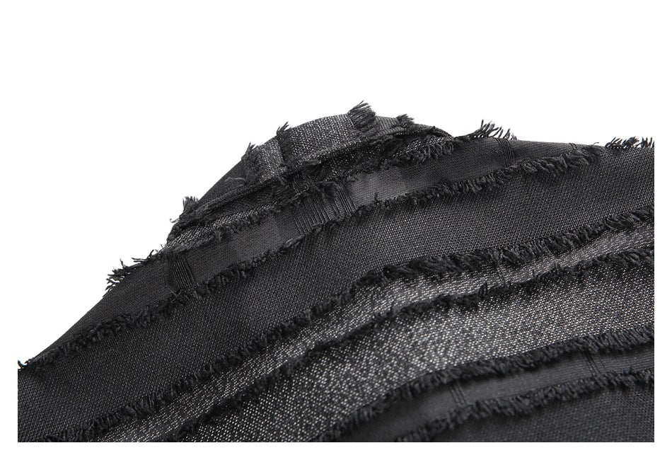 Close-up of layered black fabric bands with raw, frayed edges and a subtle metallic sheen.