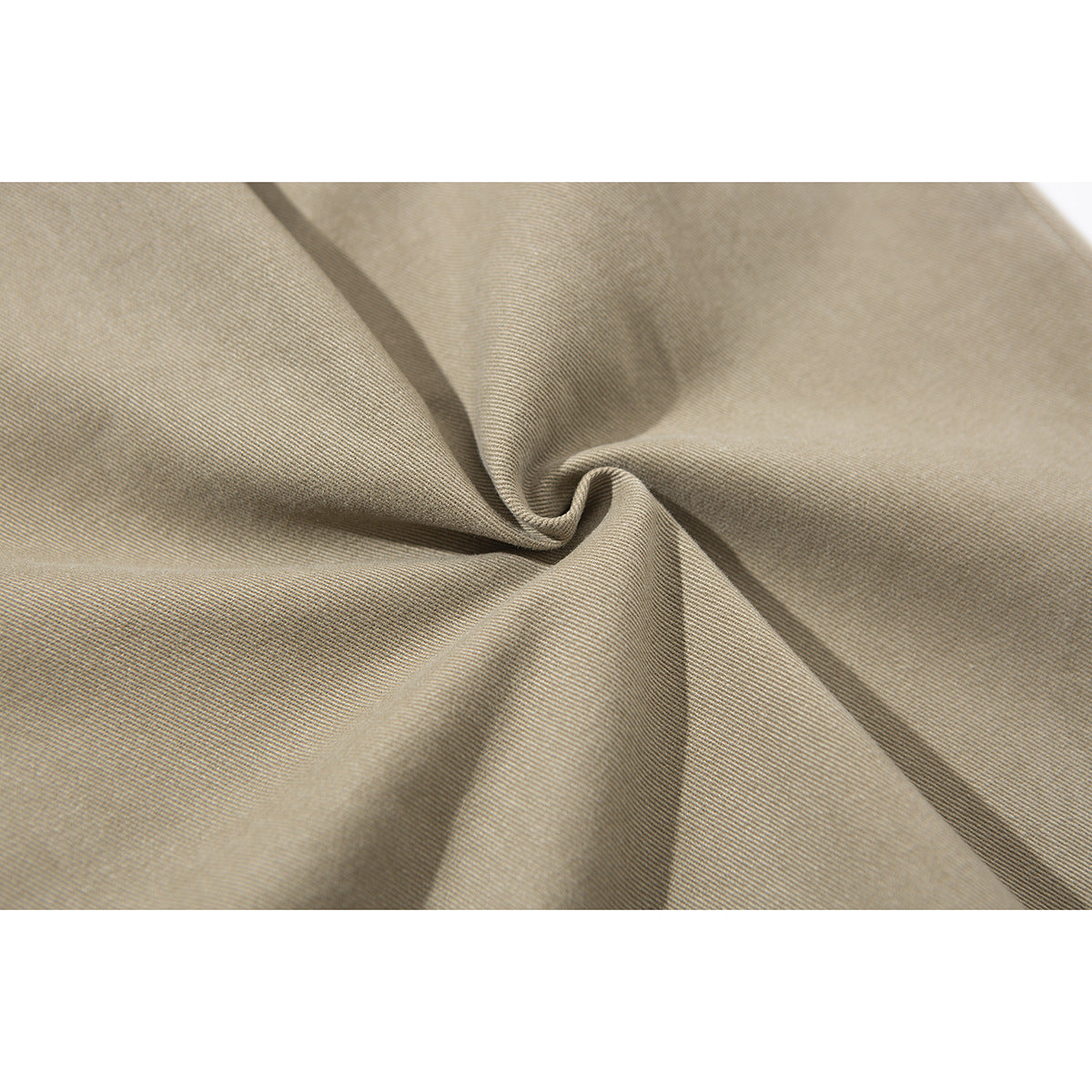 Close-up of tan fabric gathered into a twist, showing its fine diagonal texture.