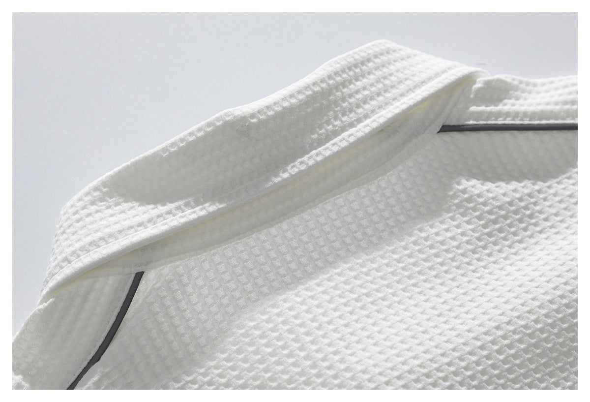 Close-up of a white pointed collar with dark gray piping on textured fabric.
