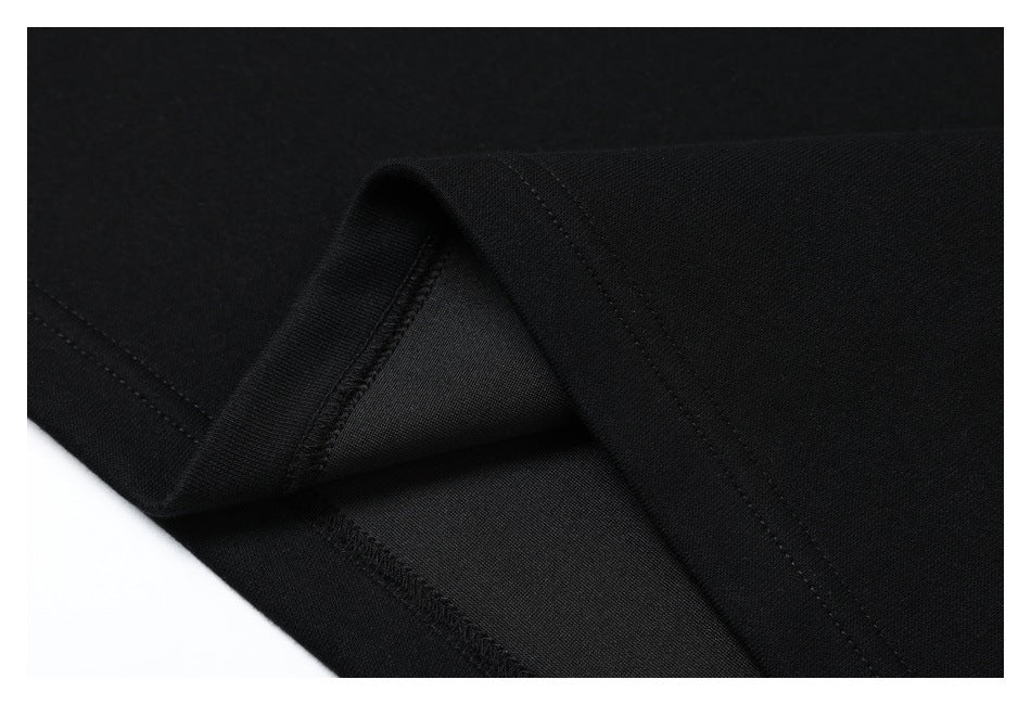 Close-up of black garment fabric folded to show a stitched seam and finished edge.