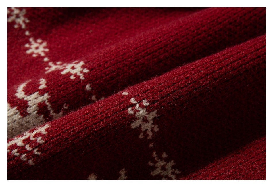 Close-up of the deep red knit texture and cream snowflake pattern.