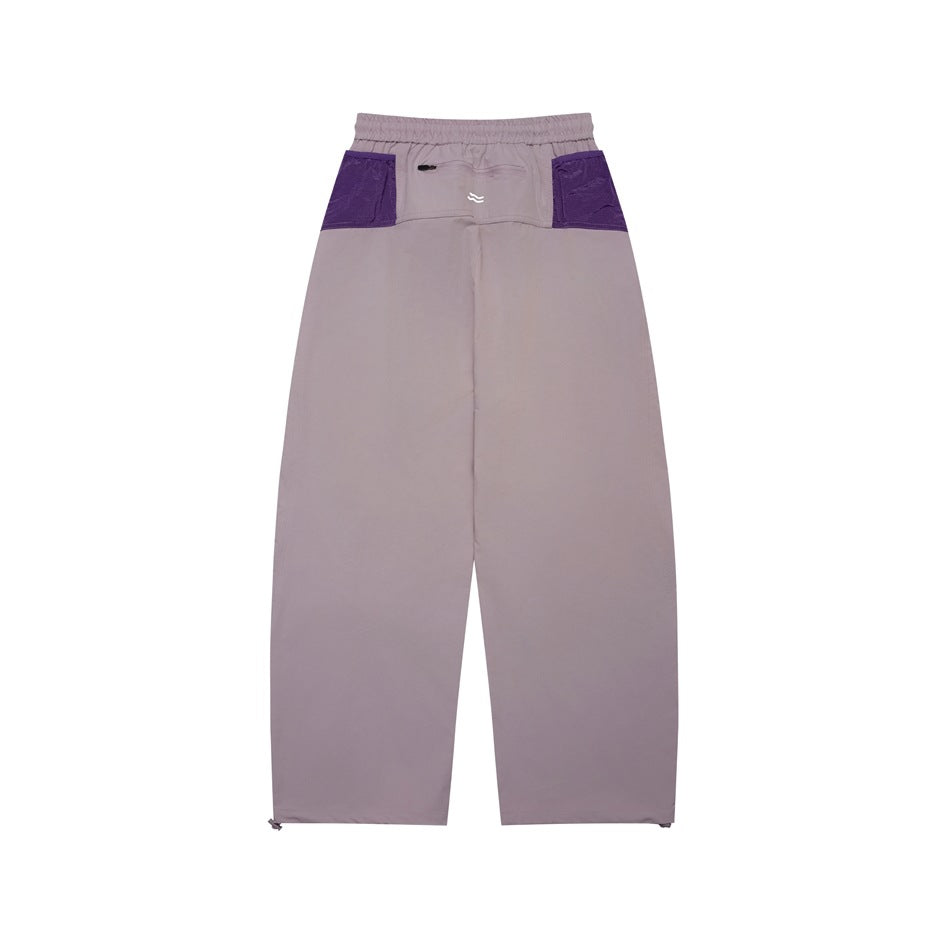Back view of mauve pants with an elastic waist, two purple pocket panels, and a small center logo.