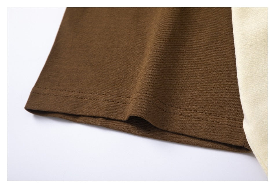 Close-up of a brown garment hem with double stitching beside an ivory panel.