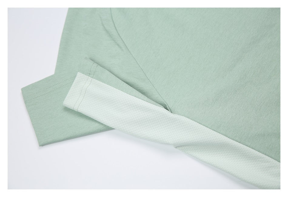 Close-up of a mint green shirt with a pale textured side panel and visible seam.