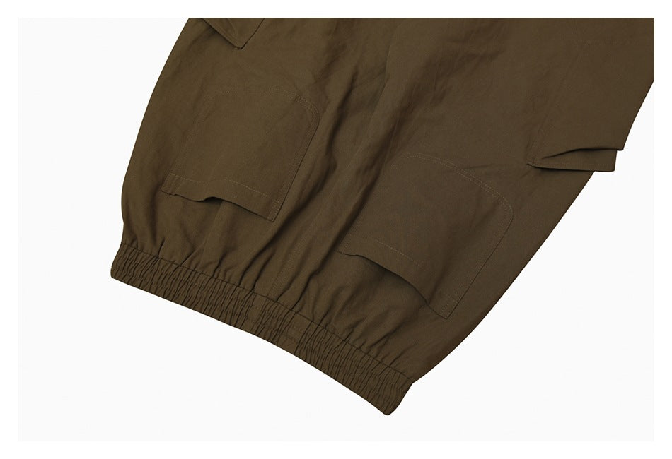 Close-up of olive-brown cargo pants showing flap pockets and an elasticized cuff.