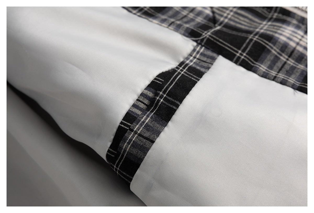 Close-up of the jacket's smooth light lining and black plaid trim at an interior seam.