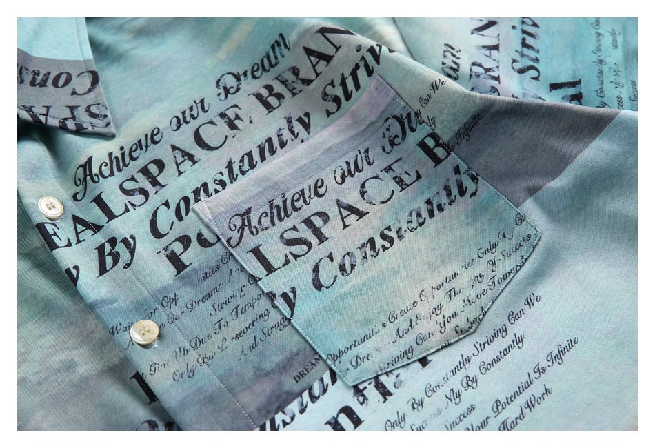 Close-up of a pale aqua printed button-up shirt, showing its chest pocket, buttons, and collar area.
