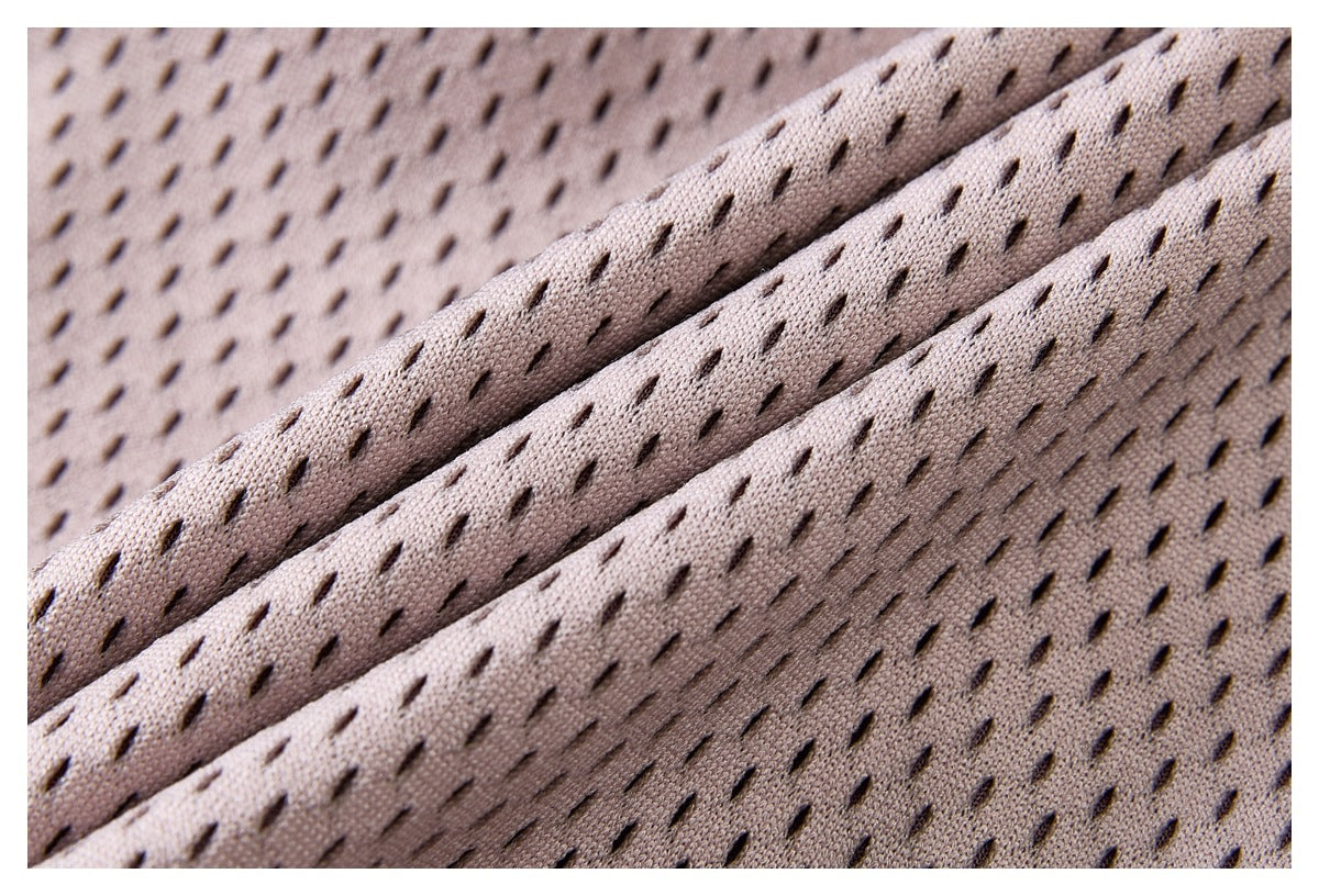 Macro view of folded pale mauve fabric with regularly spaced dark perforations.
