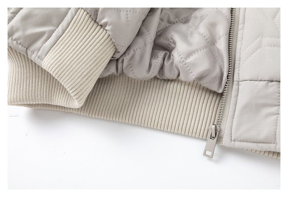 Close-up of the light gray jacket's cream rib-knit hem and cuff, lining, and front zipper.