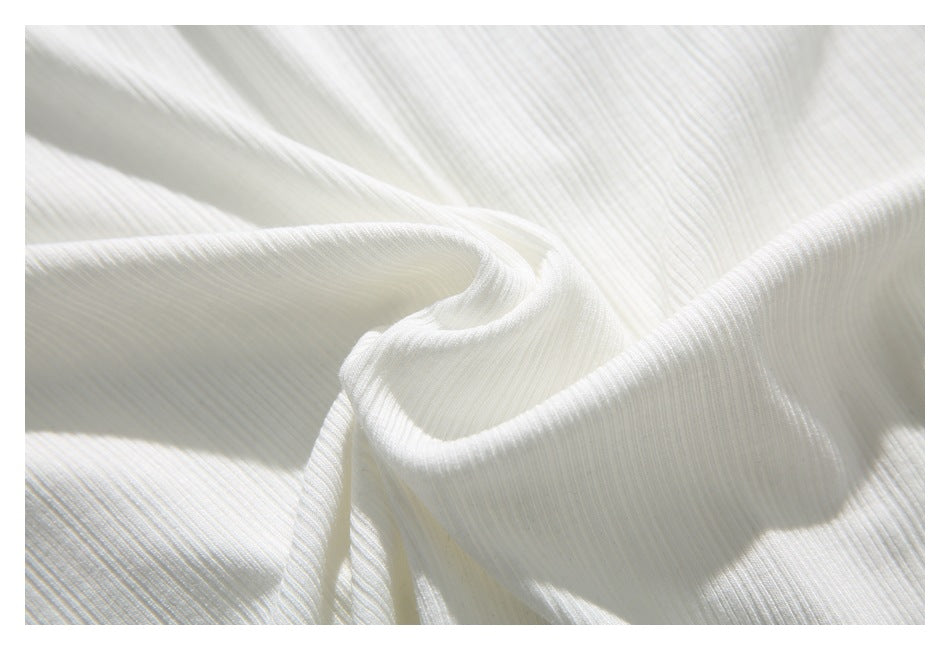 Close-up of white ribbed fabric softly draped in folds.
