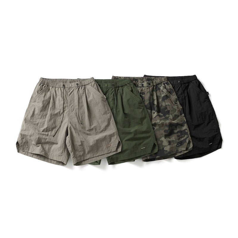 Four pairs of elastic-waist shorts displayed together in light taupe, olive green, camouflage, and black.
