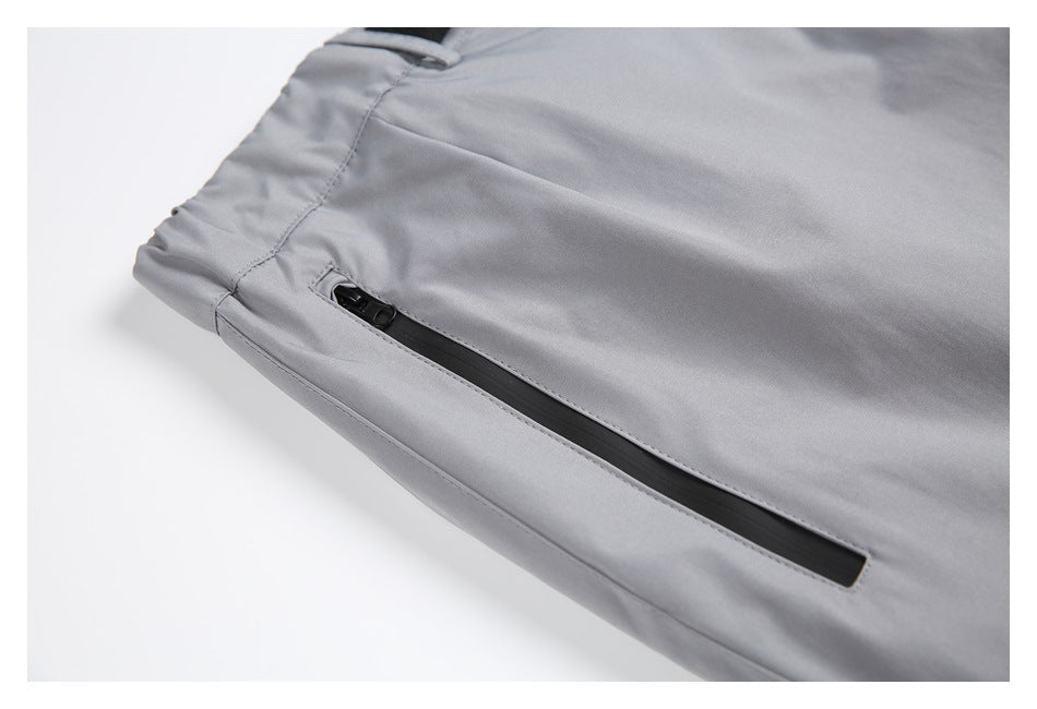 Close-up of a black zip pocket on light gray pants.