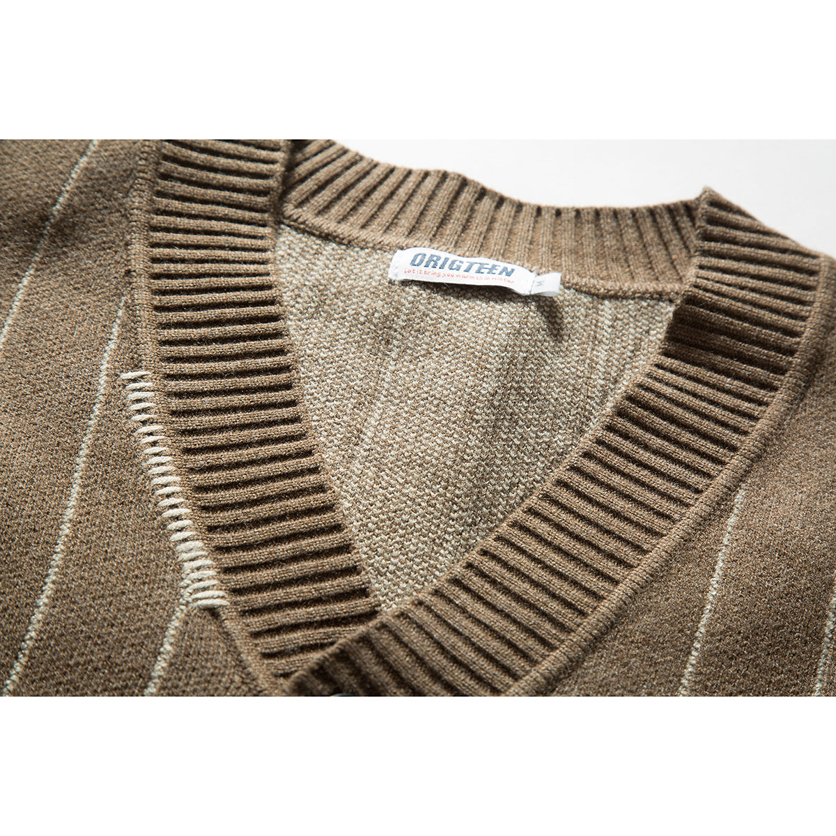 Close-up of a brown striped cardigan's ribbed V-neck and sewn-in neck label.