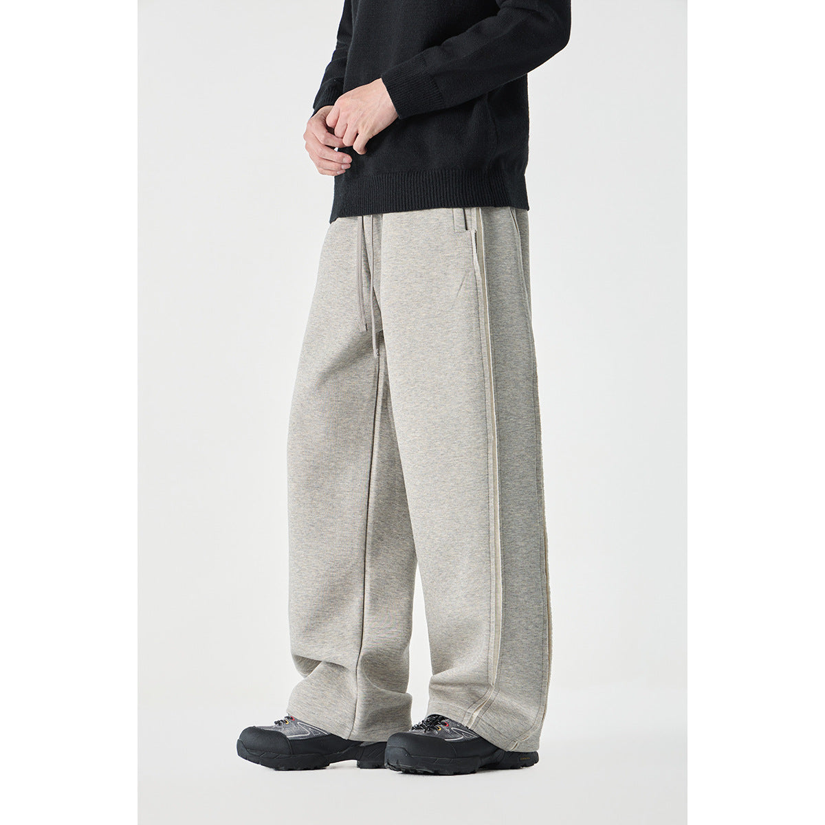 Model wearing light gray wide-leg pants with a drawstring waist and long side seams, shown at an angle.