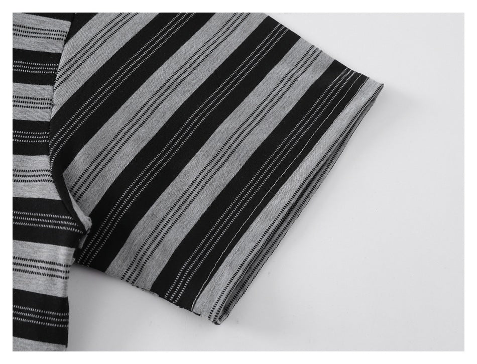 Close-up of a short sleeve and hem in alternating black and gray stripes with fine dotted bands.
