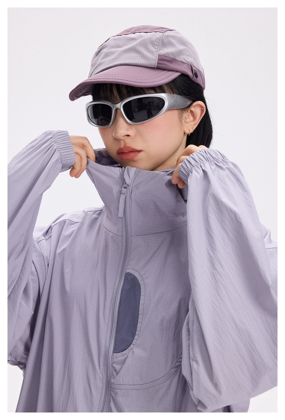 Close view of a model wearing a pale lavender hooded zip jacket with a contrasting chest detail.