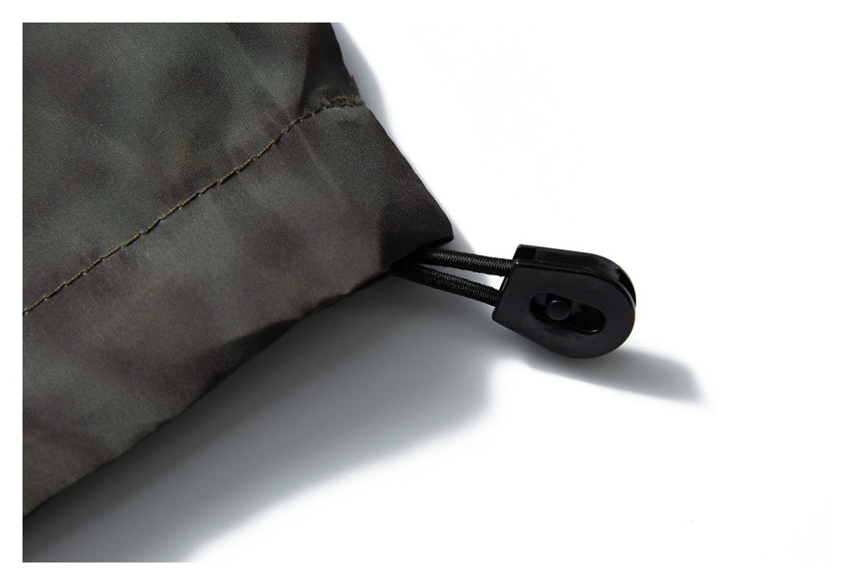 Close-up of a black drawcord toggle attached to the jacket's lower hem.