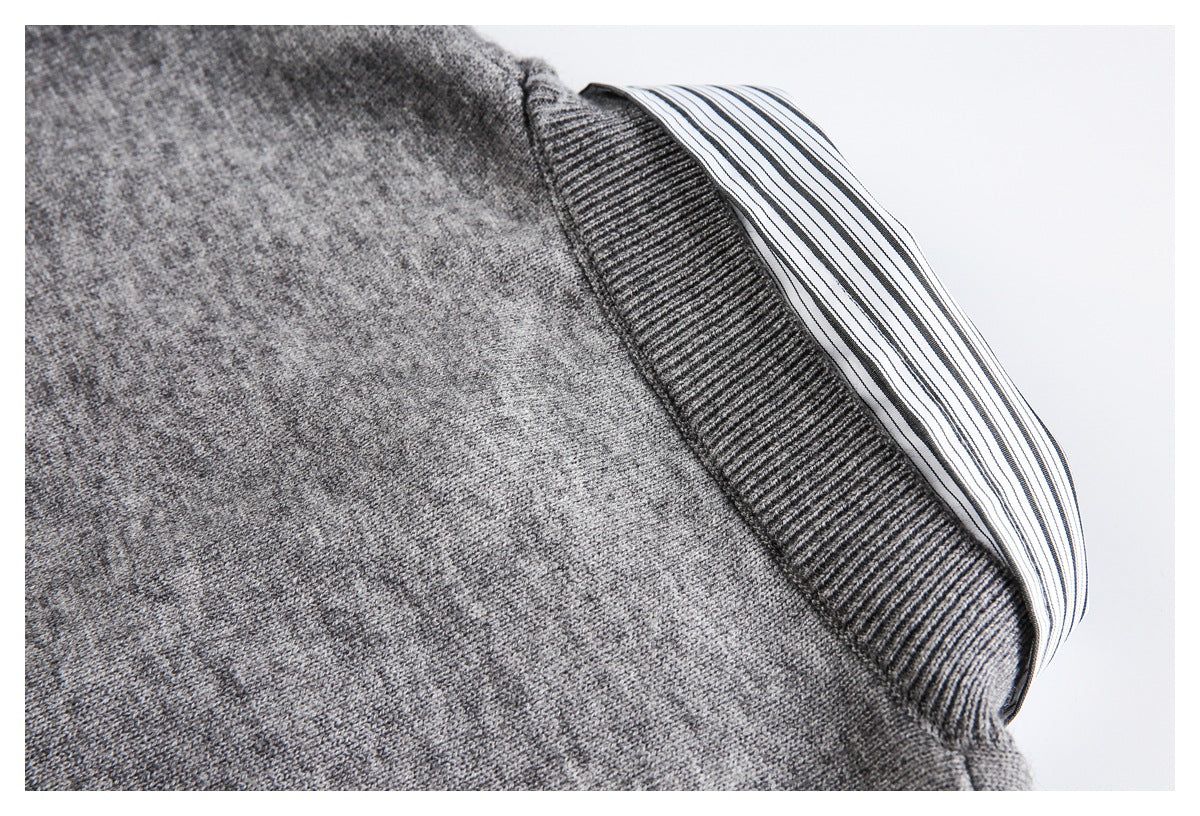 Close-up of a gray ribbed cuff with a black-and-white striped shirt cuff extending beneath it.