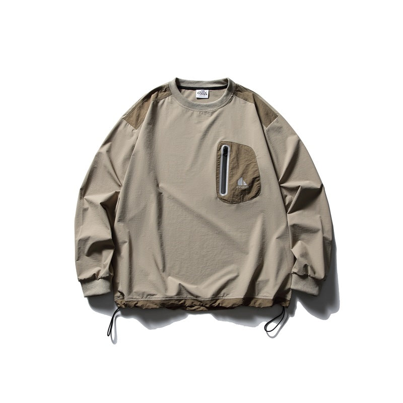 Front view of a taupe long-sleeve pullover with darker shoulder panels, a zippered chest pocket, ribbed cuffs and hem