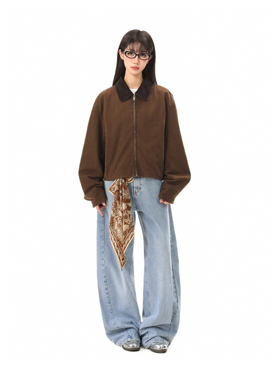 Model wearing zipped brown cropped jacket with dark collar, light wide-leg jeans and a brown printed scarf