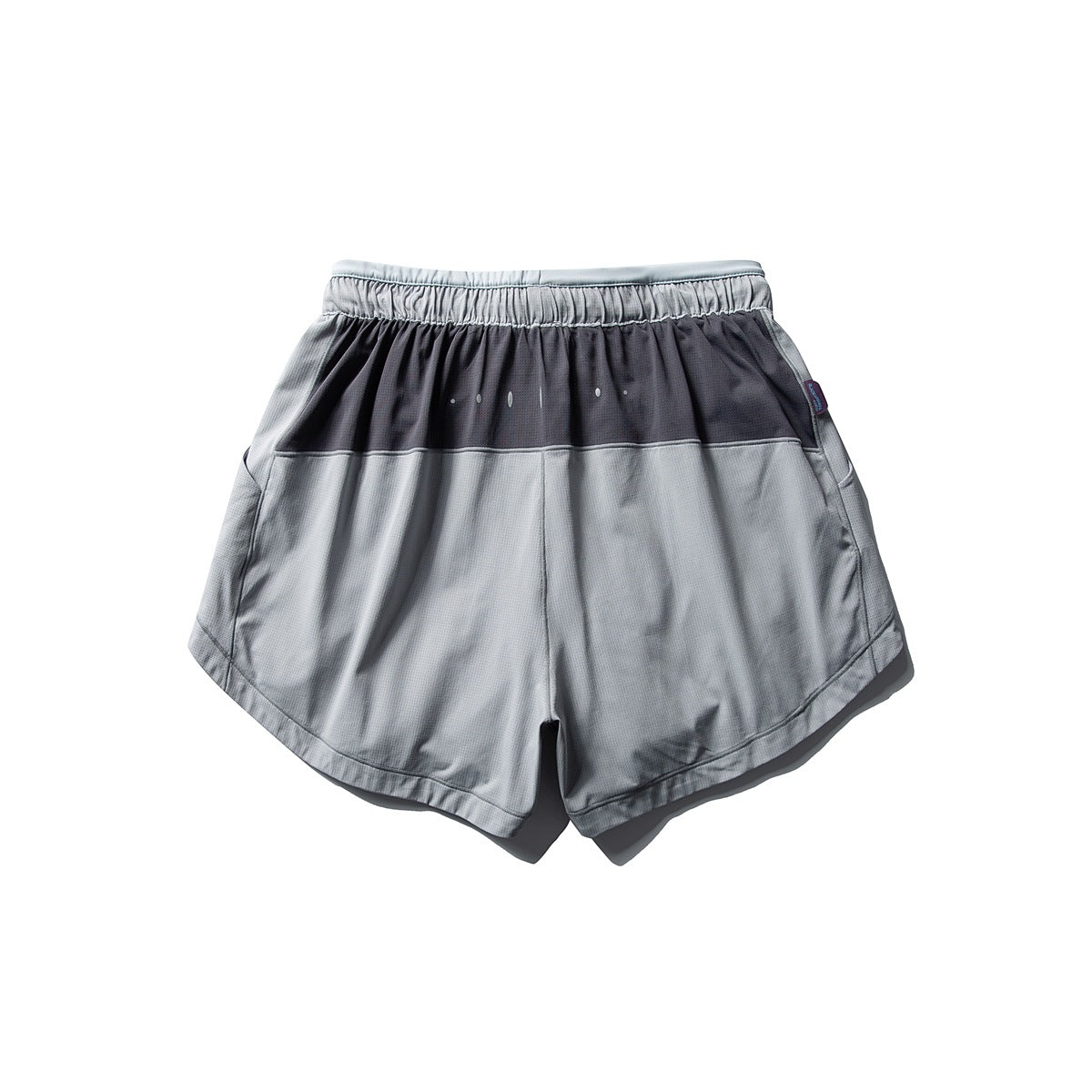 Back view of gray running shorts with an elastic waistband, dark upper panel, small dot accents and curved hems.
